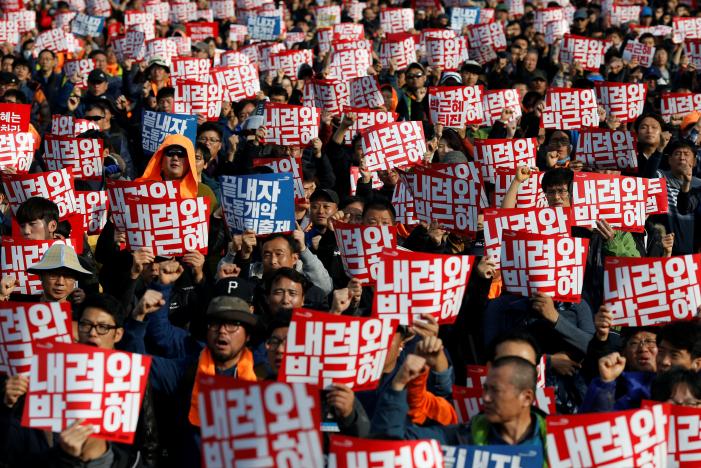 People chant slogans during a rally calling for President Park Geun-hye to step down in central Seoul, South Korea, November 12, 2016. The placards read, "Step down Park Geun-hye". REUTERS/Kim Hong-Ji